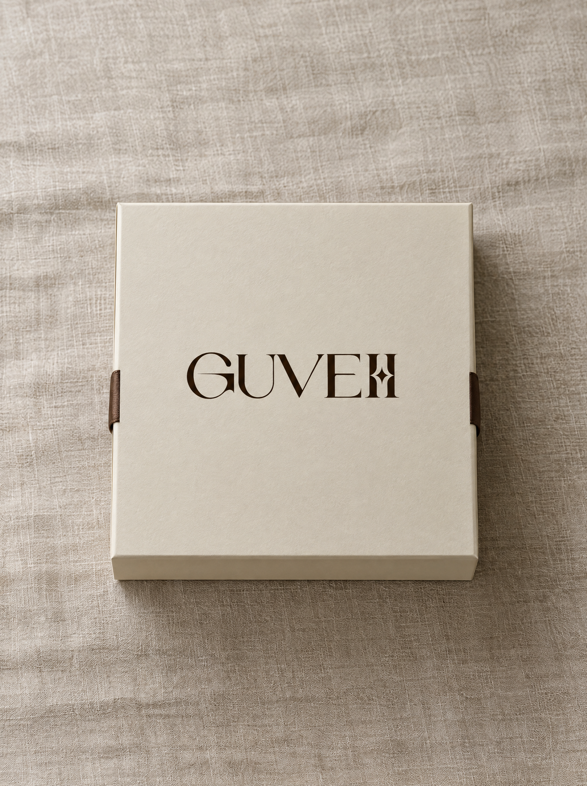 A cream GUVEII gift box with the logo centred on the lid